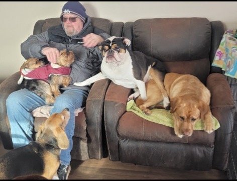 Uncle John relaxing in recliners surrounded by happy daycare dogs