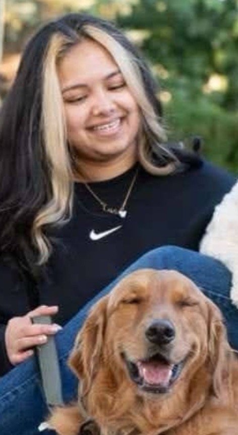 Taz smiling outdoors with a Golden Retriever